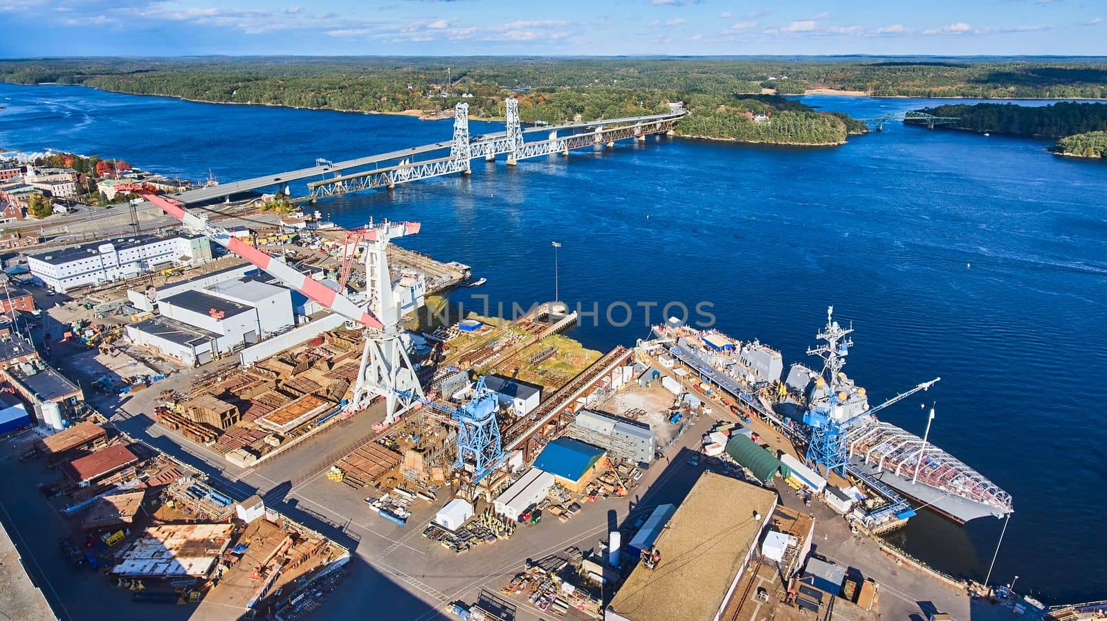 Huge shipyard on Maine river with lift bridge and ships under construction by njproductions