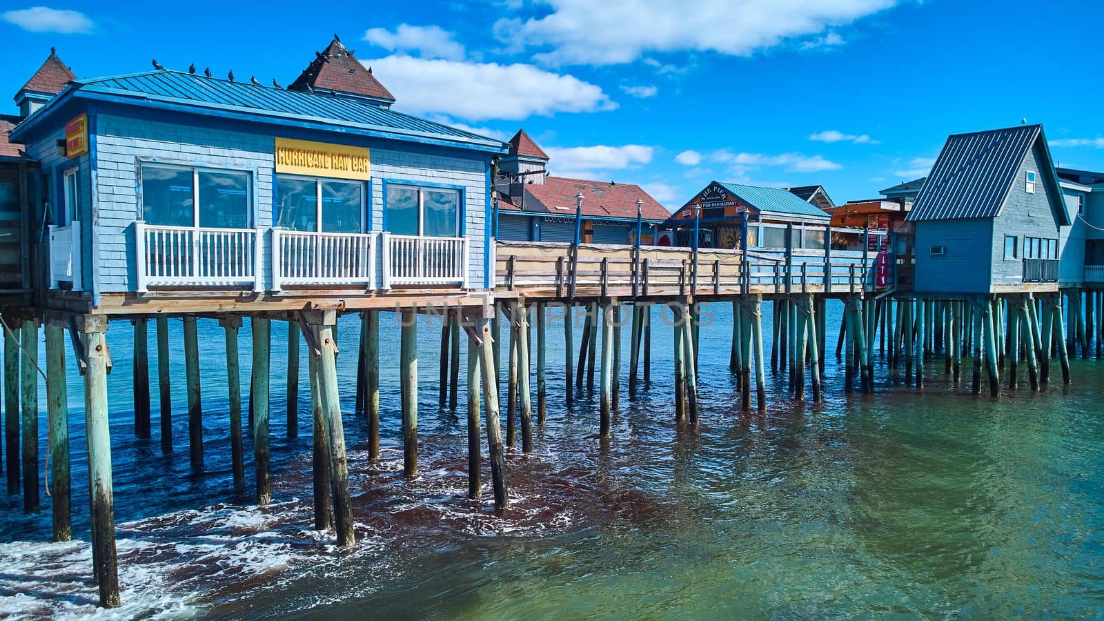Image of Old wood pier covered in buildings on Maine coast of ocean