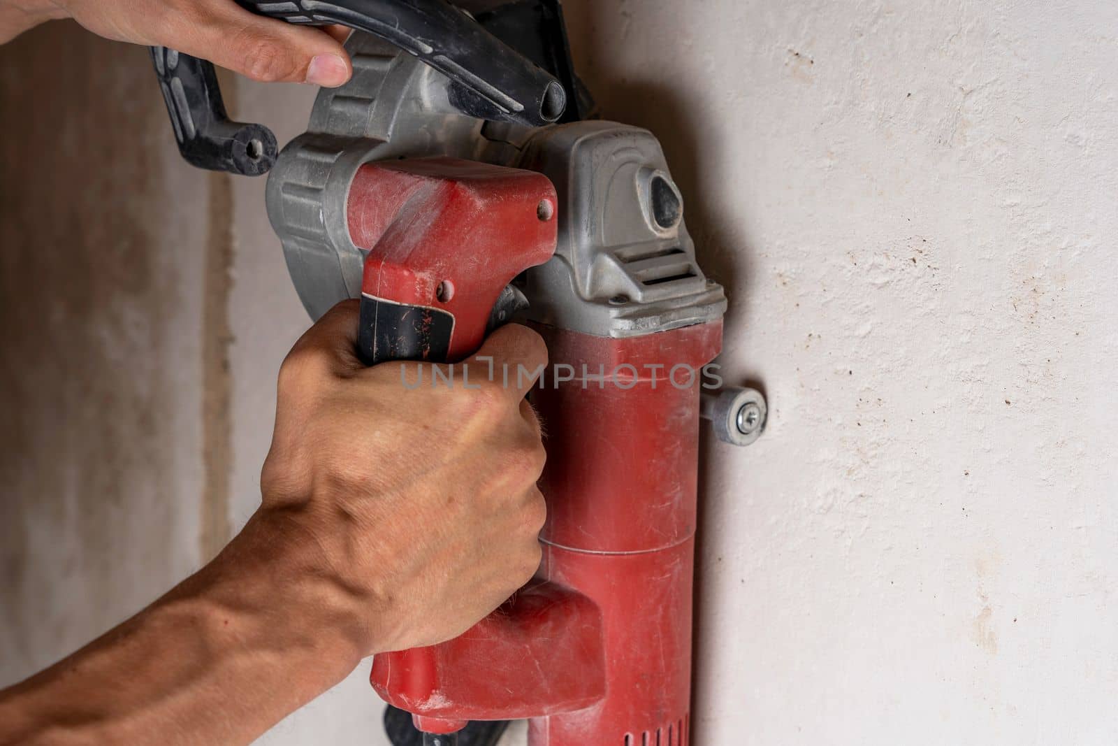 professional construction power tool for cutting strob in the hands of a worker during the renovation of the apartment. A hand-held power tool with two diamond discs for cutting grooves in the wall for laying electrics. Professional tool. Close-up