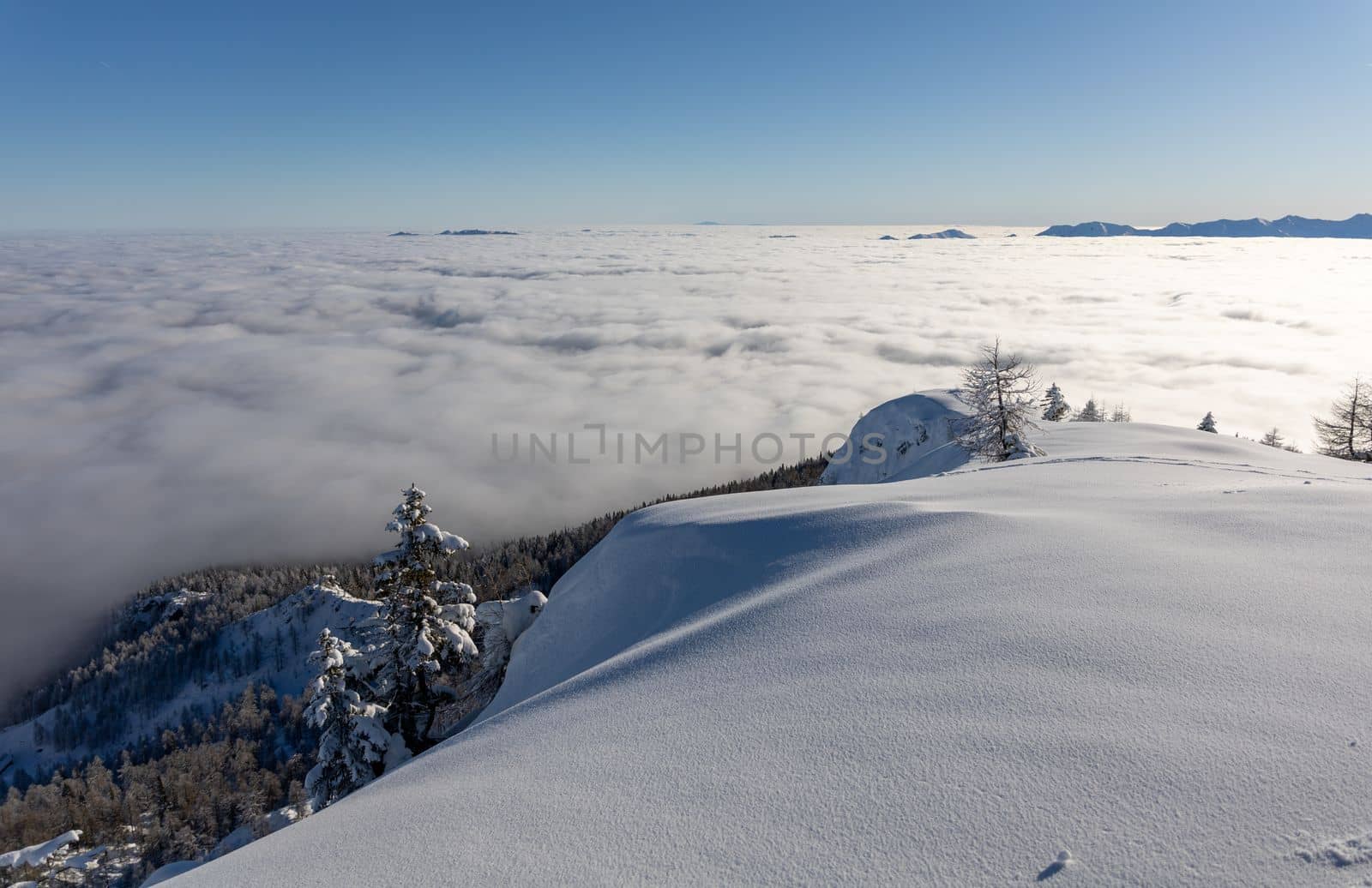 Winter mountains covered with snow landscape over clouds by Chechotkin