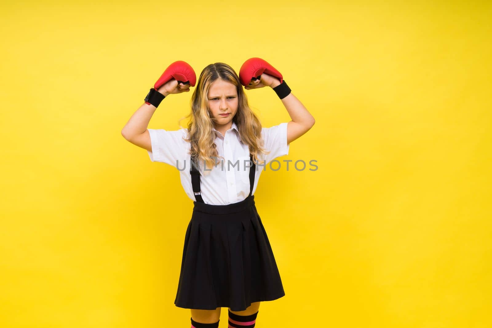 Adorable little girl boxer practicing punches in studio by Zelenin