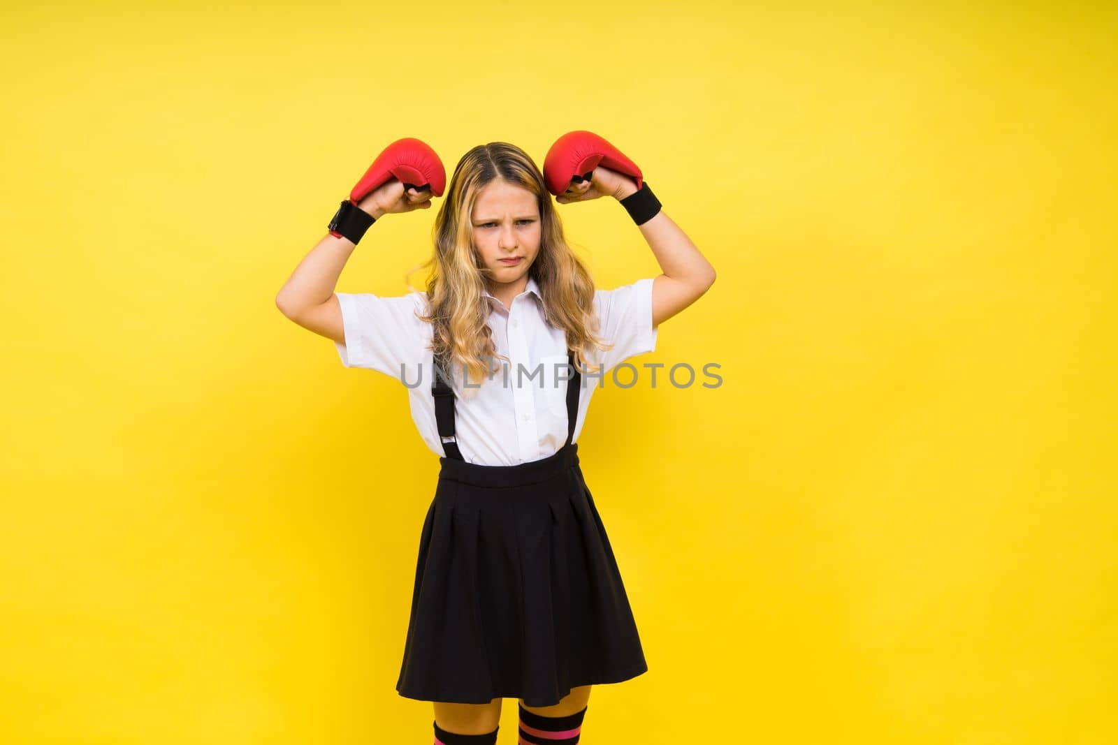 Adorable little girl boxer practicing punches in a studio