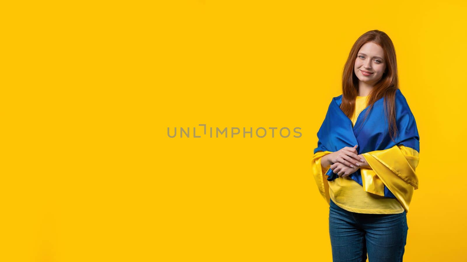Happy woman with national Ukrainian flag on yellow. Copy space banner. Ukraine, patriot, victory in war celebration, Independence day. High quality photo