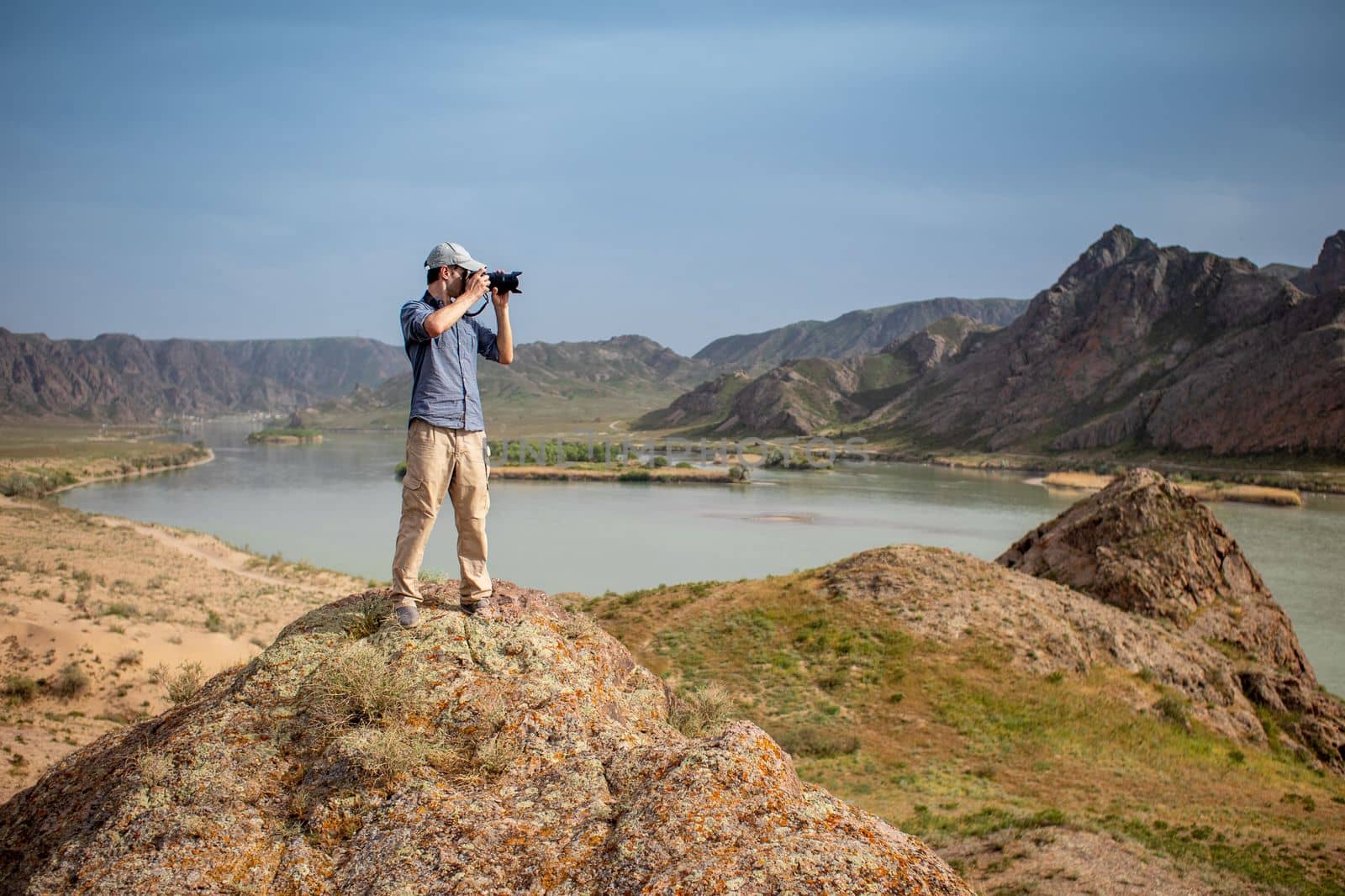 Photographer shoots a landscape from the top of a mountain on the banks of the Ili River in the Almaty region of Kazakhstan.