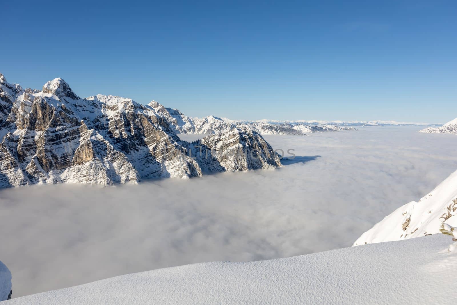 Winter mountains covered with snow landscape over clouds. High quality photo