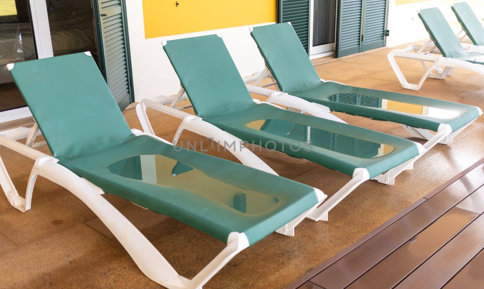 wet green sunbeds with paddles after rain. High quality photo