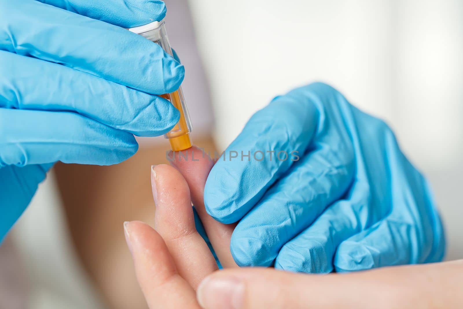 Doctor piercing patients finger with lancet in clinic closeup. Taking blood for close-up analysis, a clinical blood test. Finger prick