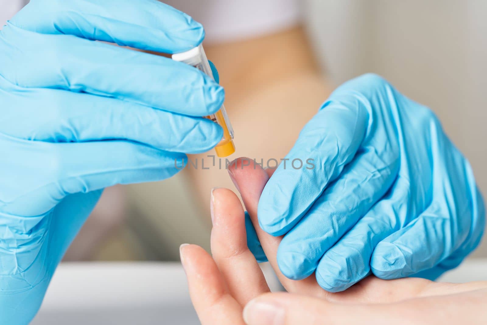 Doctor piercing patients finger with lancet in clinic closeup. Taking blood for close-up analysis, a clinical blood test. Finger prick