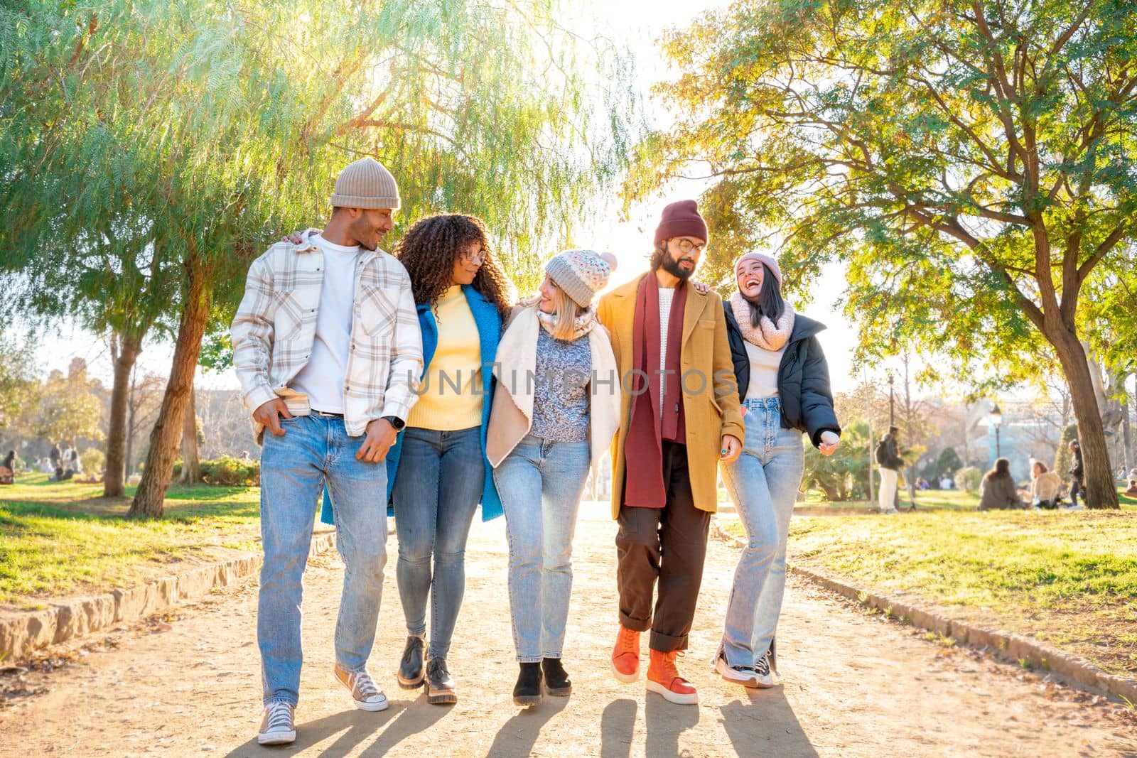 Cheerful group of friends walking outdoors in the park having fun together. Happy people on vacation by PaulCarr