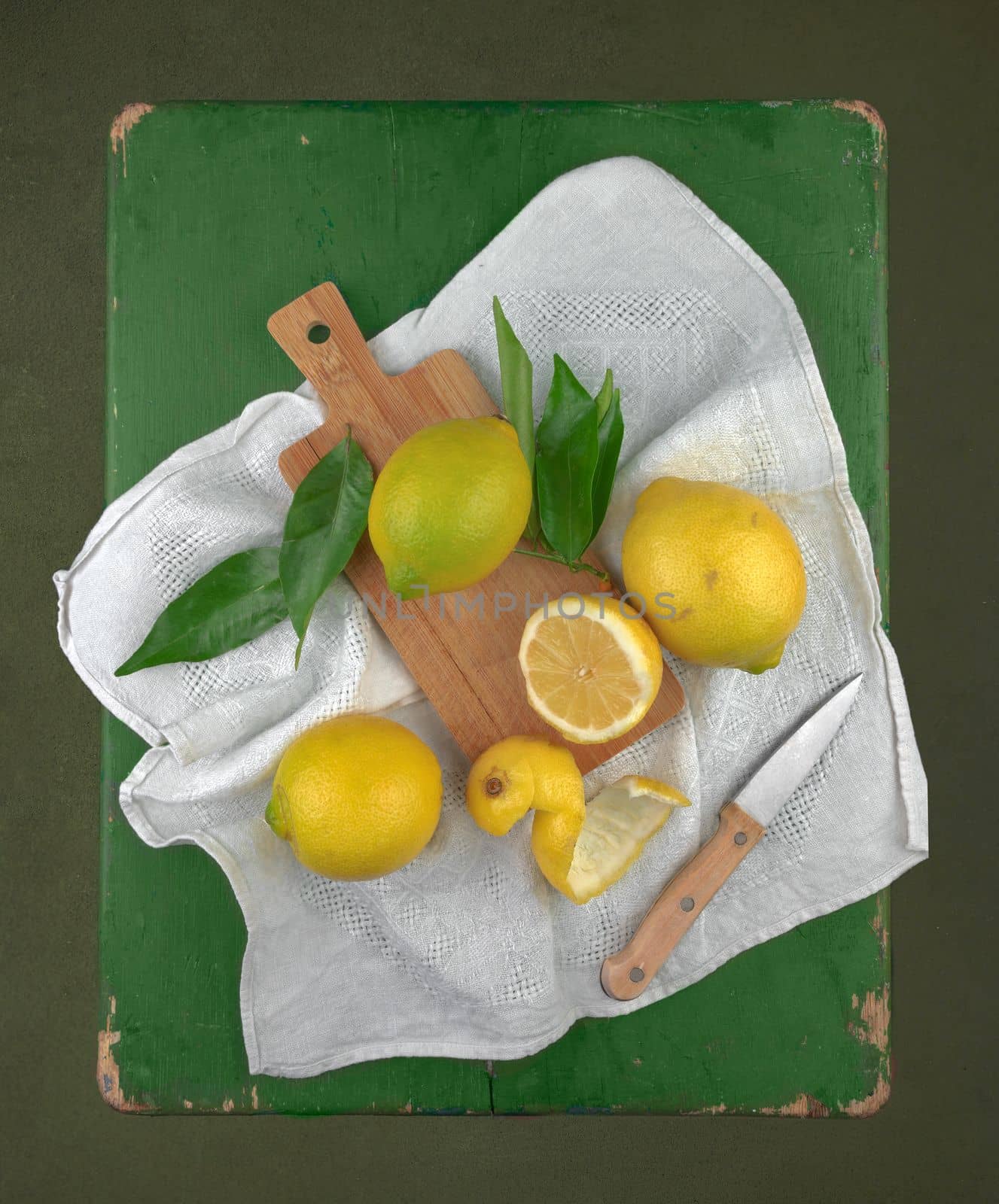 Still life in the technique of painting with lemon and slices on a vintage green wooden table on a black background as banner or wall picture. High quality photo