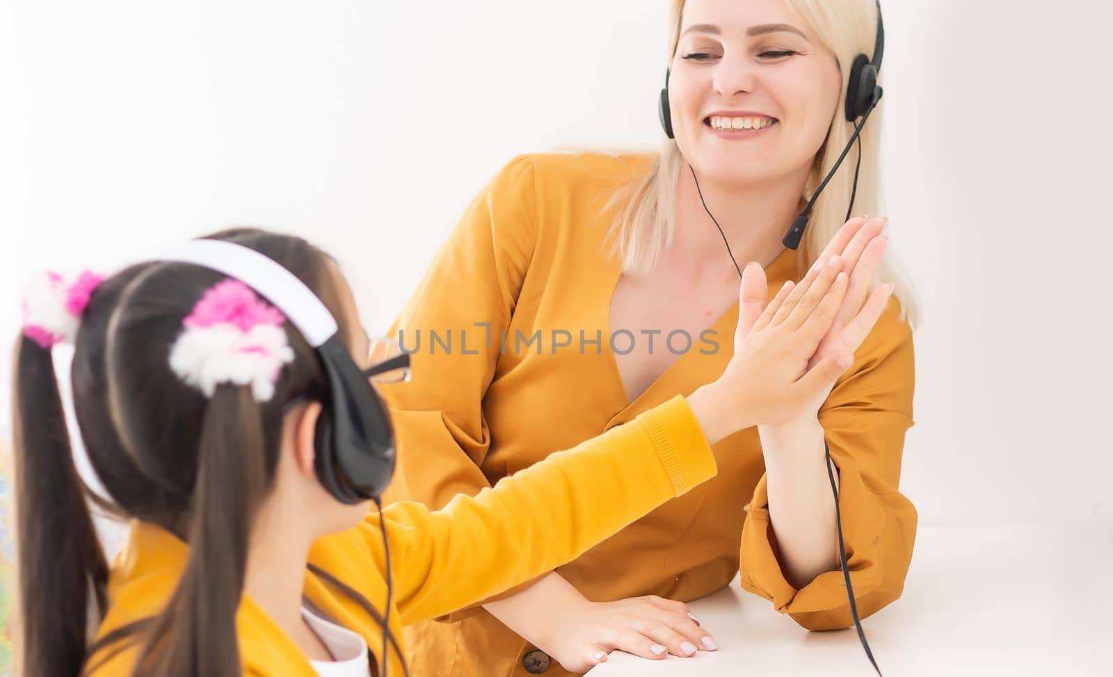 Private lesson. Attentive young woman tutor teacher help little girl pupil with studying math language correct mistakes explain learning material. Smiling mother assist small daughter with home task.