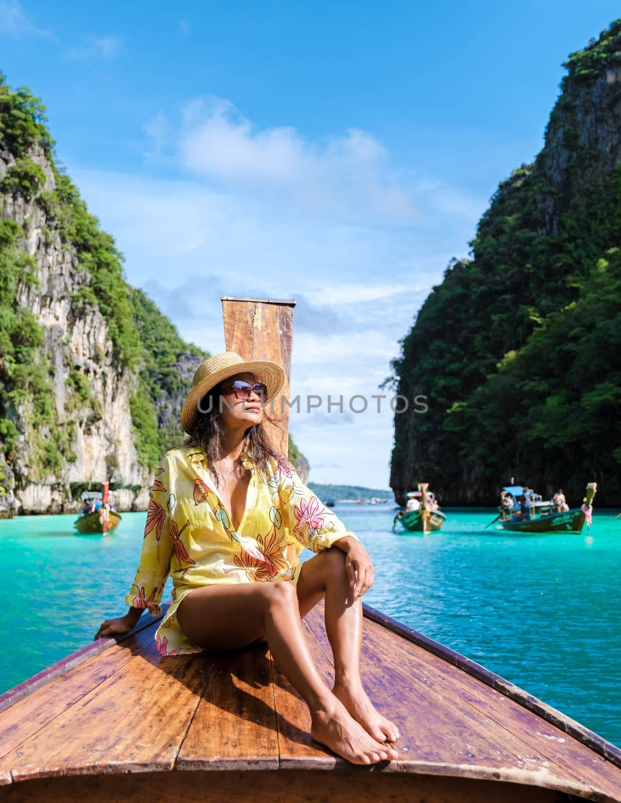 Asian women in front of a longtail boat at Kho Phi Phi Thailand, women in front of a boat at Pileh Lagoon