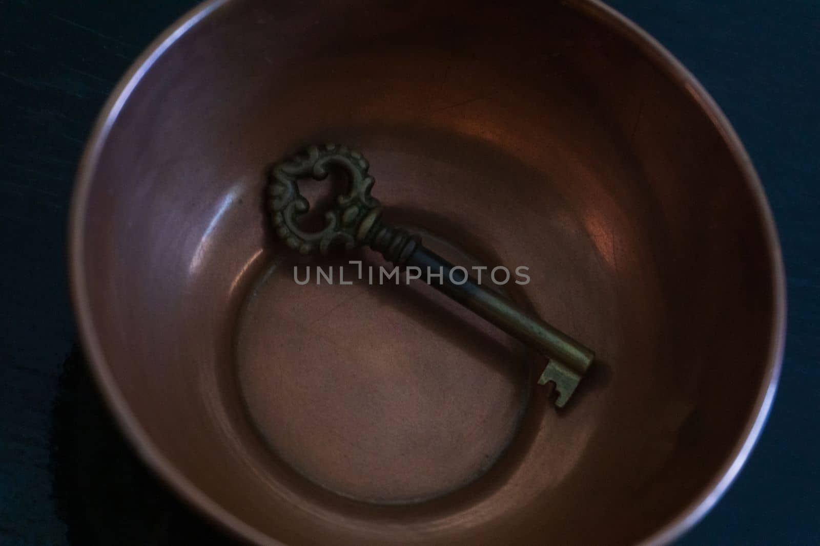 Antique metal key in antique copper bowl by Challlenger