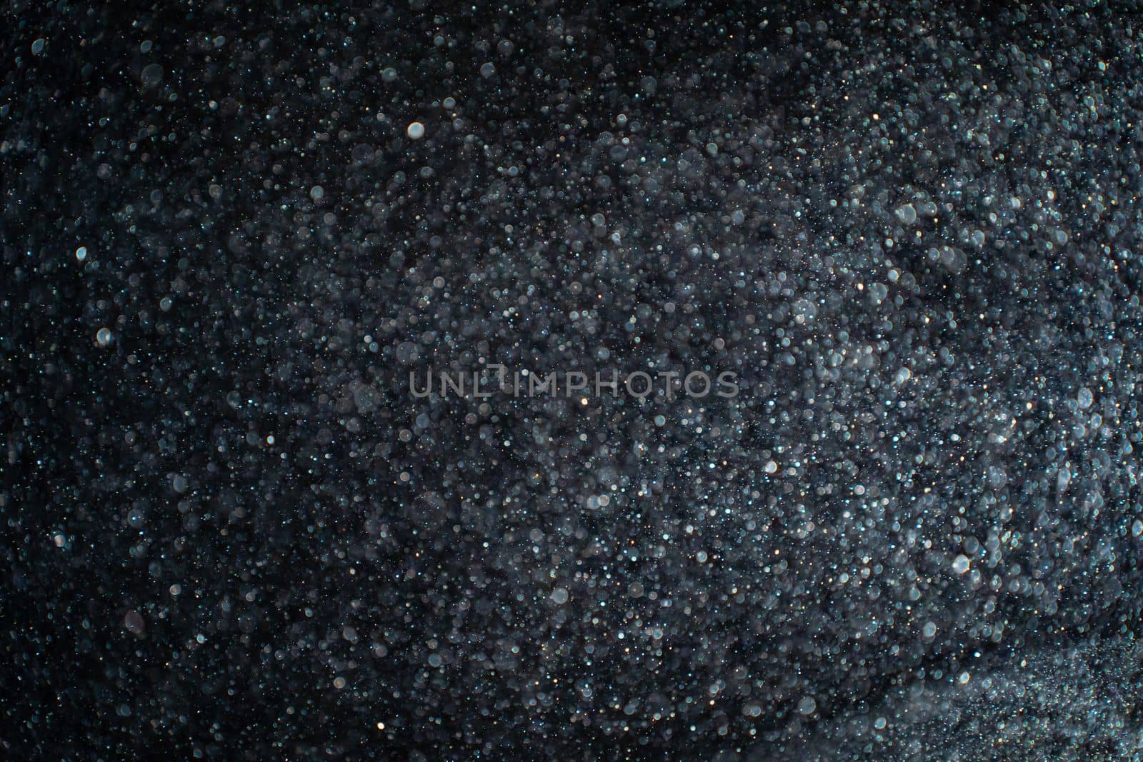 Abstract real dust particles on black background. Glittering sparkling bokeh overlay design with copy space for text. High quality photo