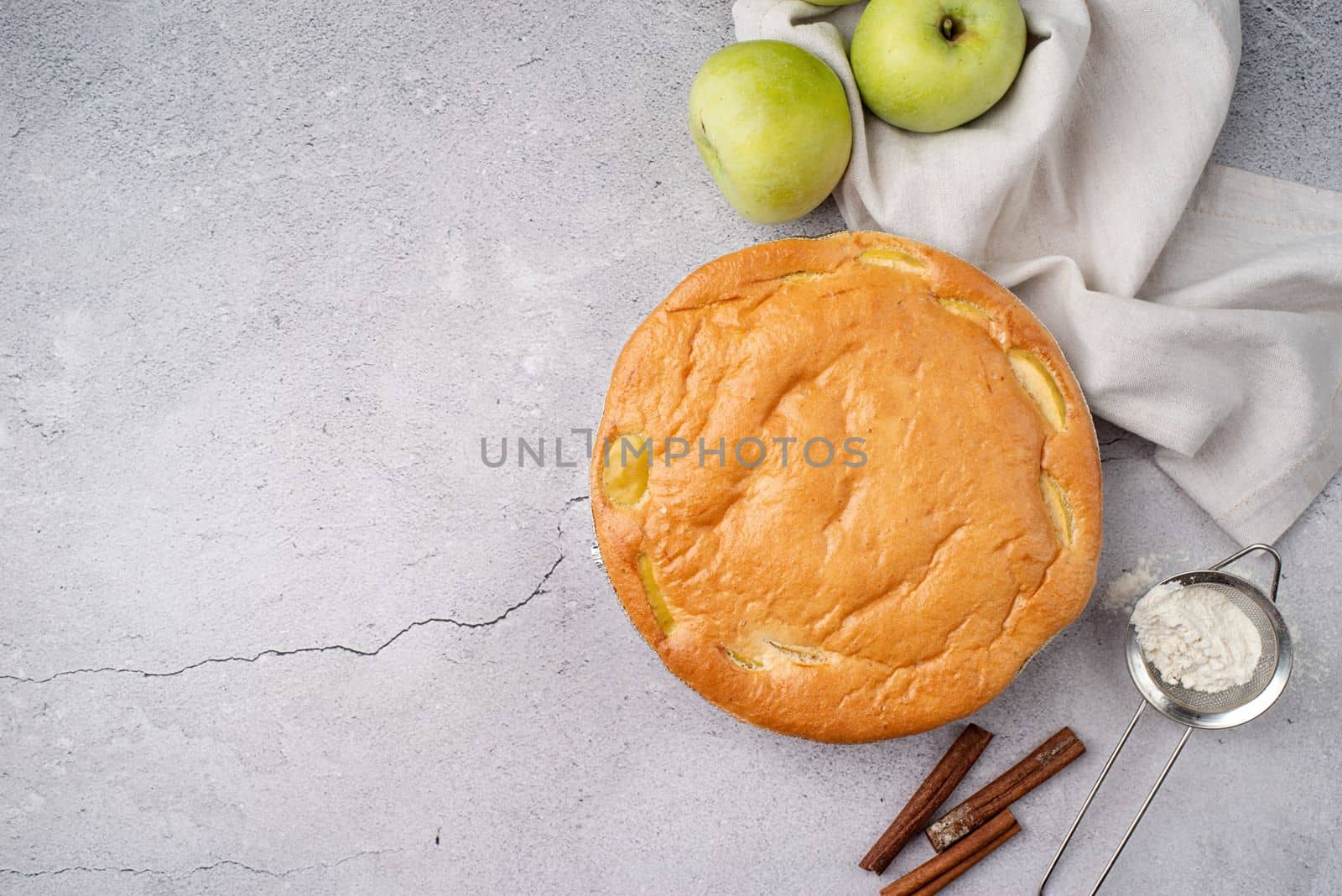 Traditional charlotte apple pie charlotte on concrete table with fresh apple and cinnamon , view from above copy space