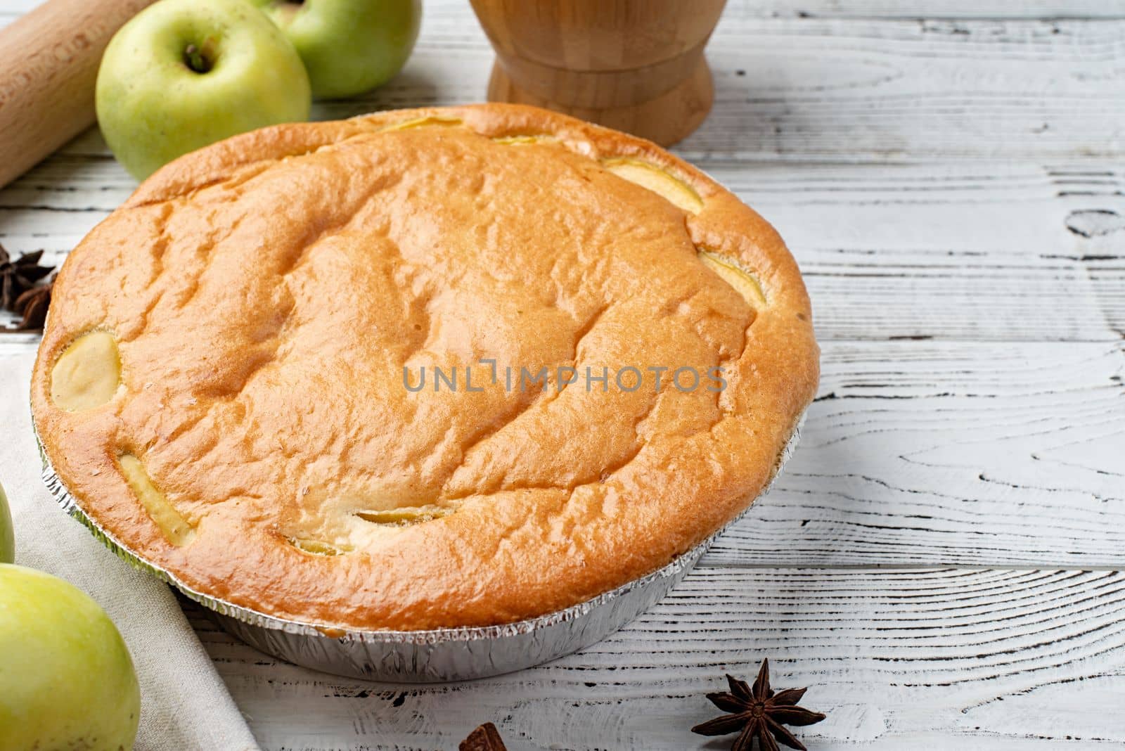 Traditional charlotte apple pie charlotte on concrete table with fresh apple and cinnamon , view from above