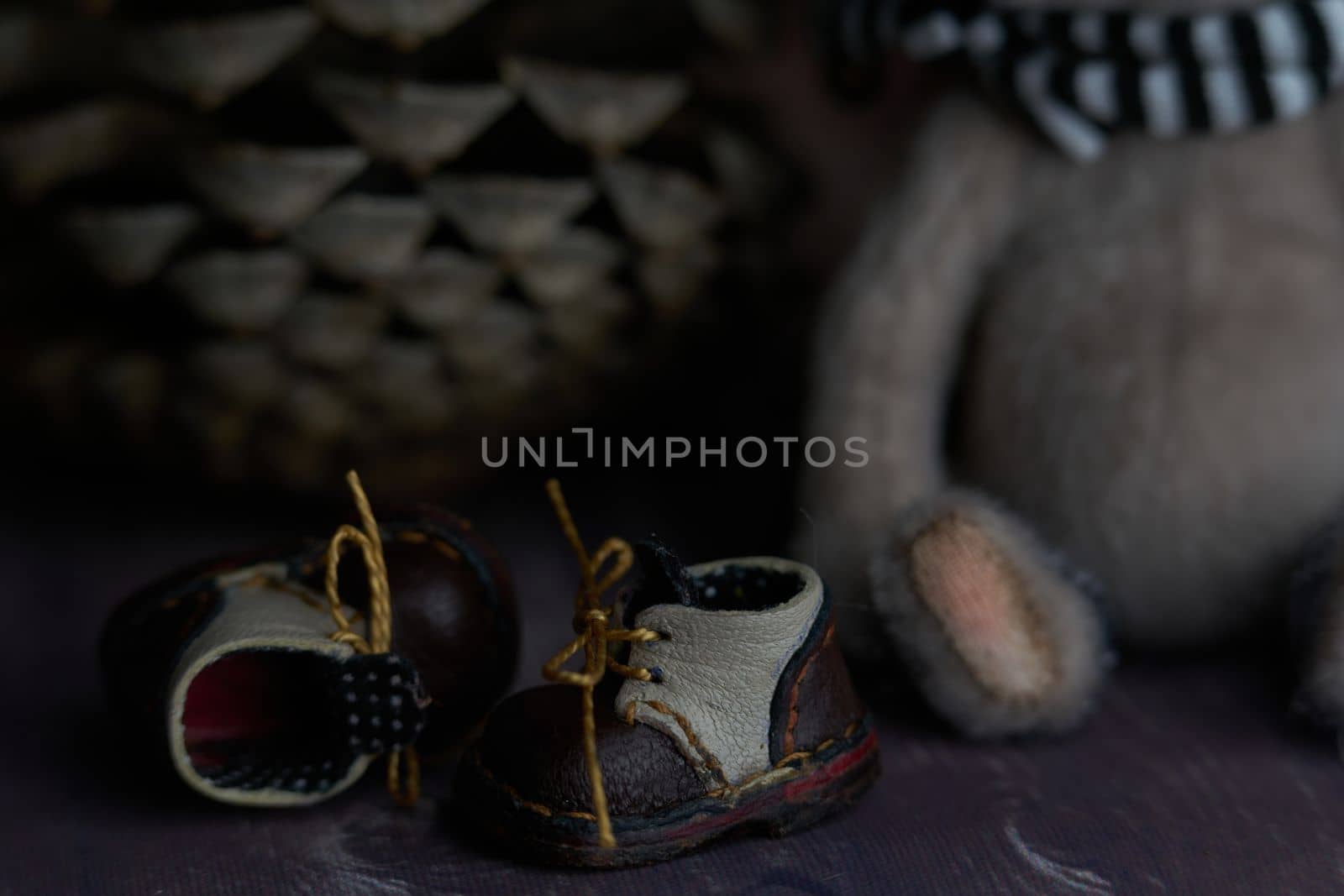 leather small shoes near the feets of teddy bear. the concept of light industry for the manufacture of stylish fashionable shoes for children with small feet and their parents. High quality photo