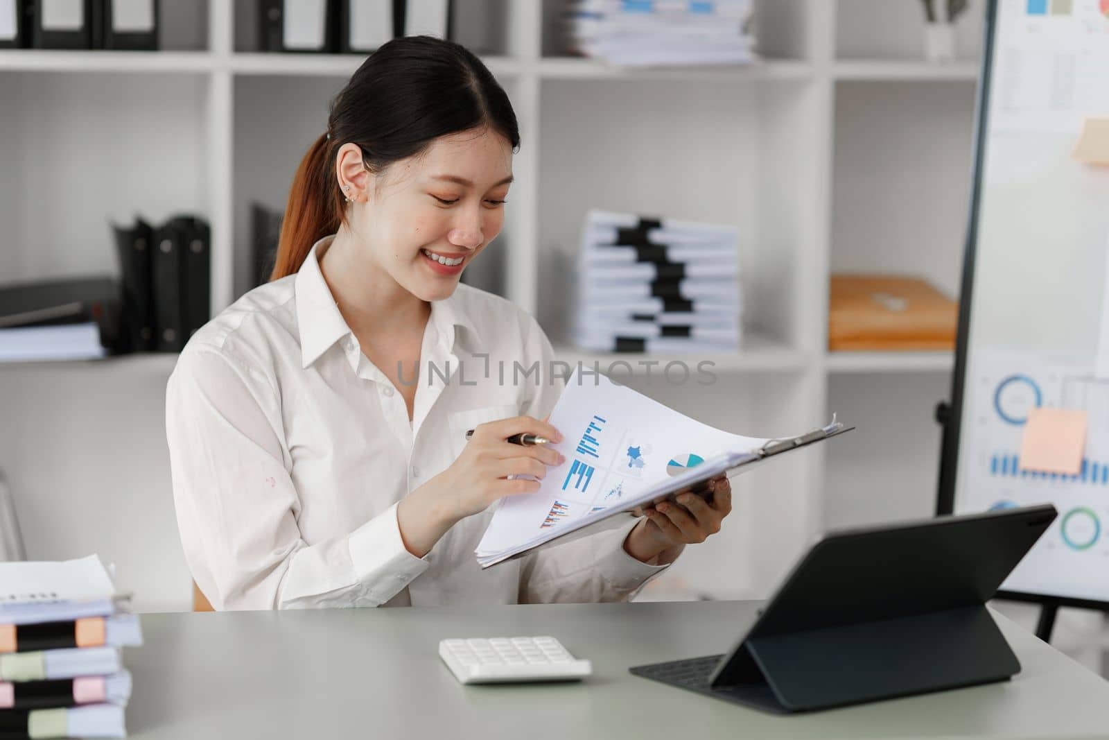 Pleasant positive business woman using digital tablet at home office.