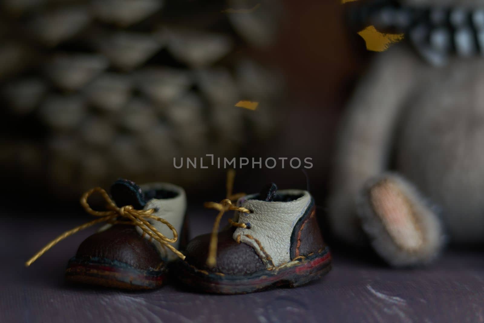 leather small shoes near the feets of teddy bear. the concept of light industry for the manufacture of stylish fashionable shoes for children with small feet and their parents by Costin