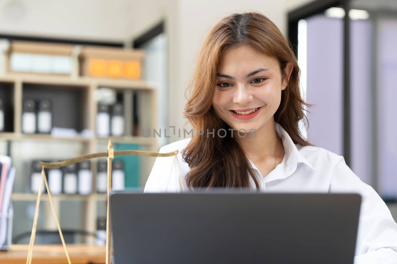 woman and lawyers discussing contract papers with brass scale on wooden desk in office. Law, legal services, advice, Justice and real estate concept.