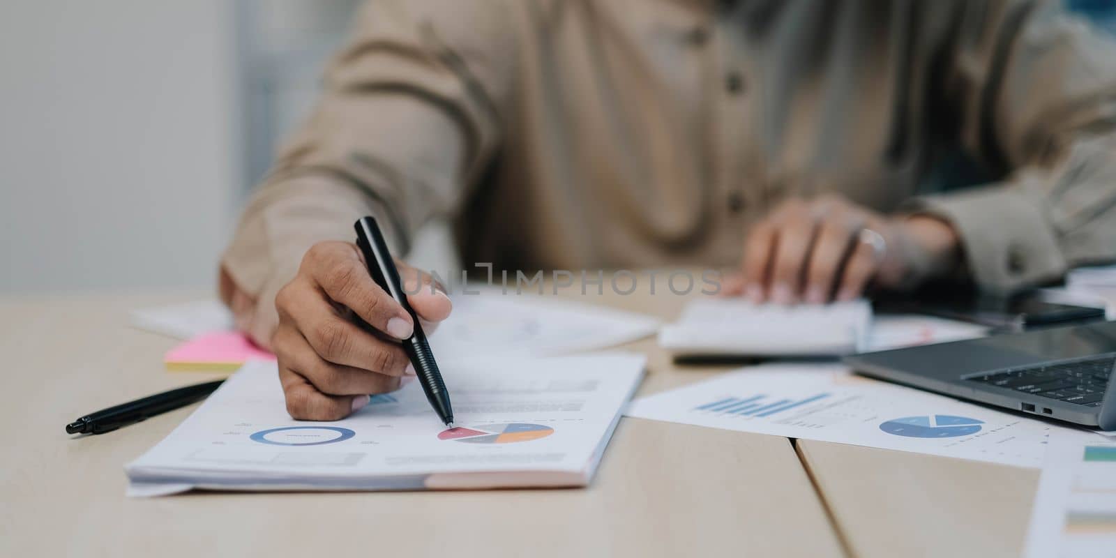 Close-up of the hands of a businessman using a calculator to check financial accounts check the company's expenses and budget. by wichayada