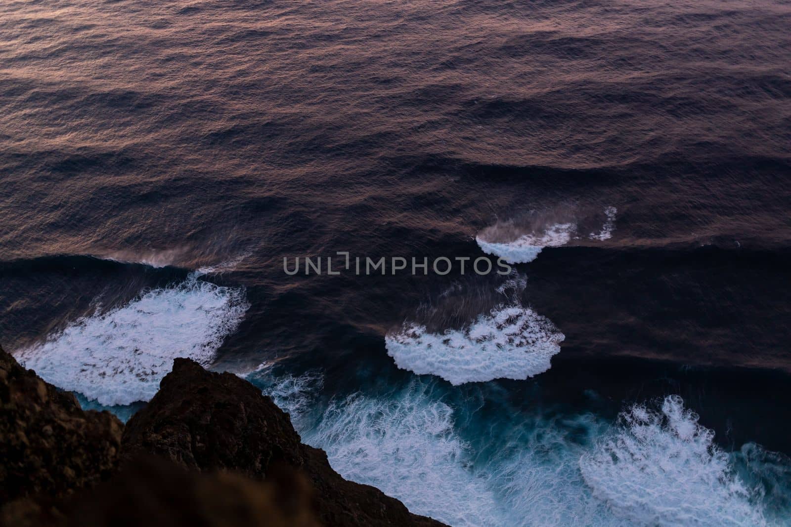 ocean surf waves at sunset view from above by Chechotkin