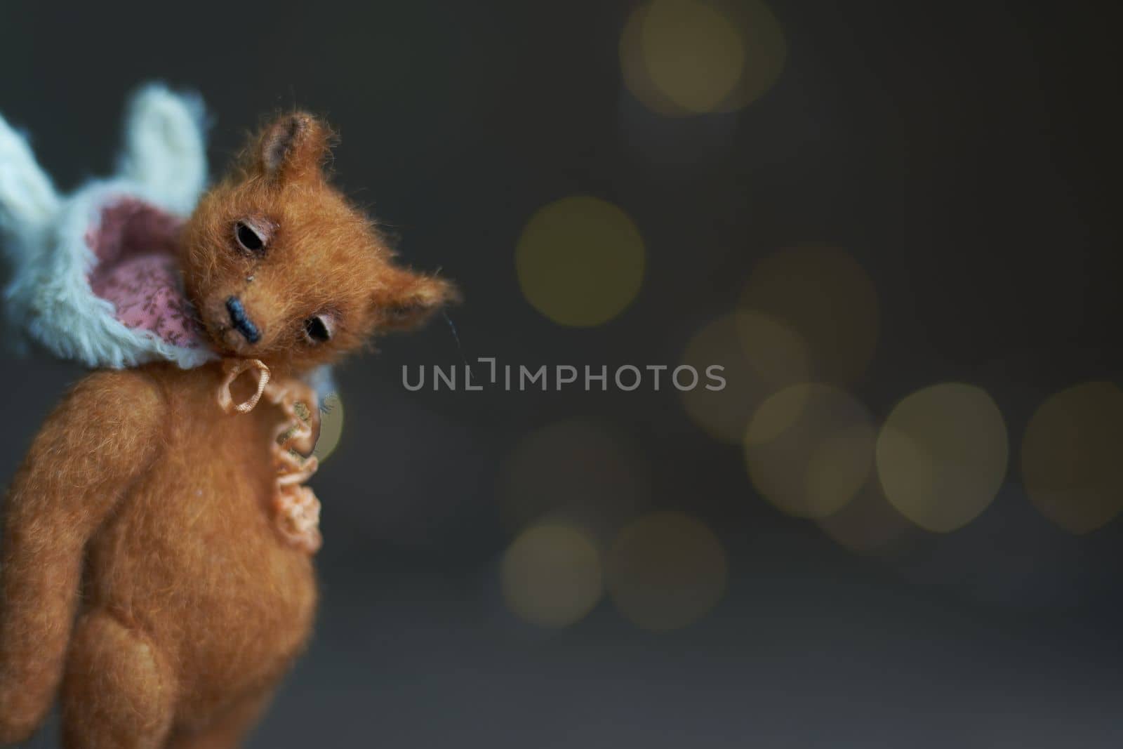 Cute teddy bear isolated on light background. Holiday glowing backdrop. Defocused background with blinking light. Blurred Bokeh. copy space. by Costin