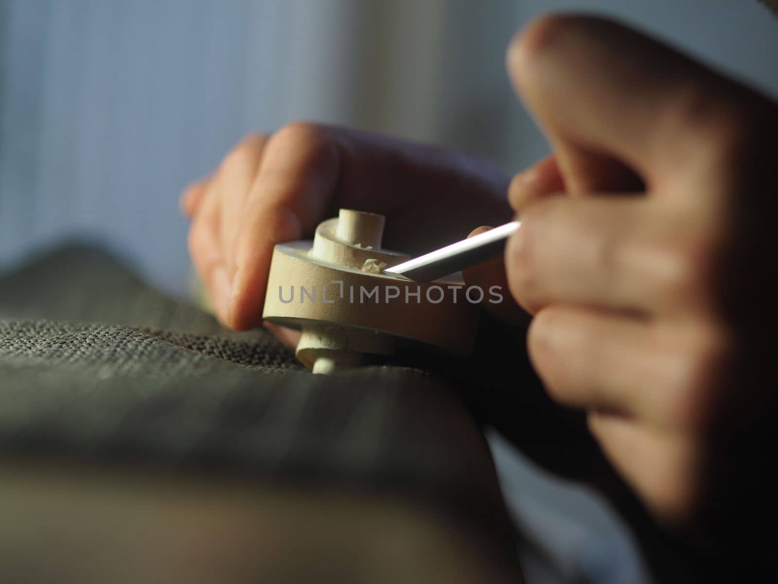 violinmaker working on a handmade contemporary stringed instrument scroll