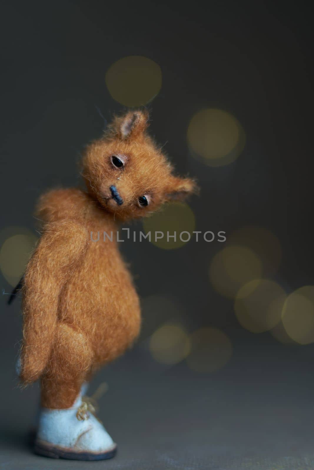 Cute teddy bear isolated on light background. Holiday glowing backdrop. Defocused background with blinking light. Blurred Bokeh. copy space. High quality photo