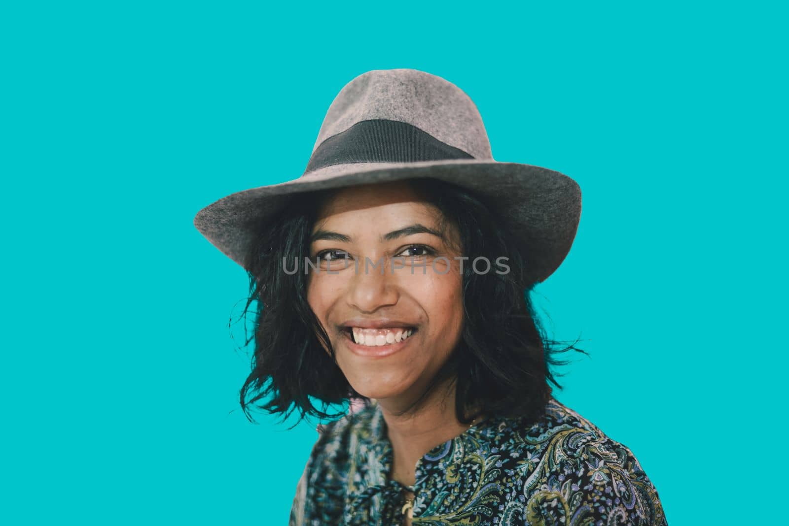 portrait of a young cheerful happy south asian woman with hat by verbano