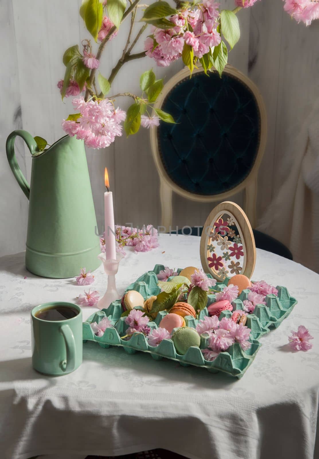 colored macarons on the table against the background of blooming sakura and a cup of coffee, Easter still life, High quality photo 