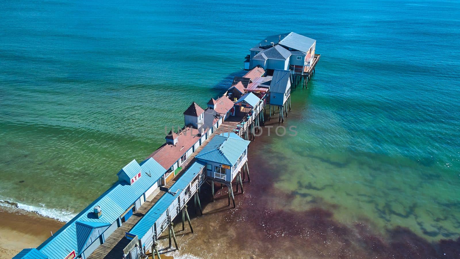 Image of Shops cover large pier on ocean coast of Maine