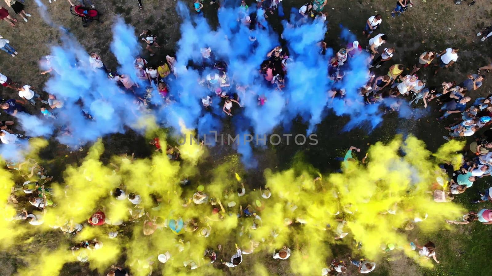 CHERKASY, UKRAINE - AUGUST 24, 2018 : aerial video with drone, Independence Day celebration, festival of colors, people throw up yellow and blue paints in sky, national flag by djtreneryay
