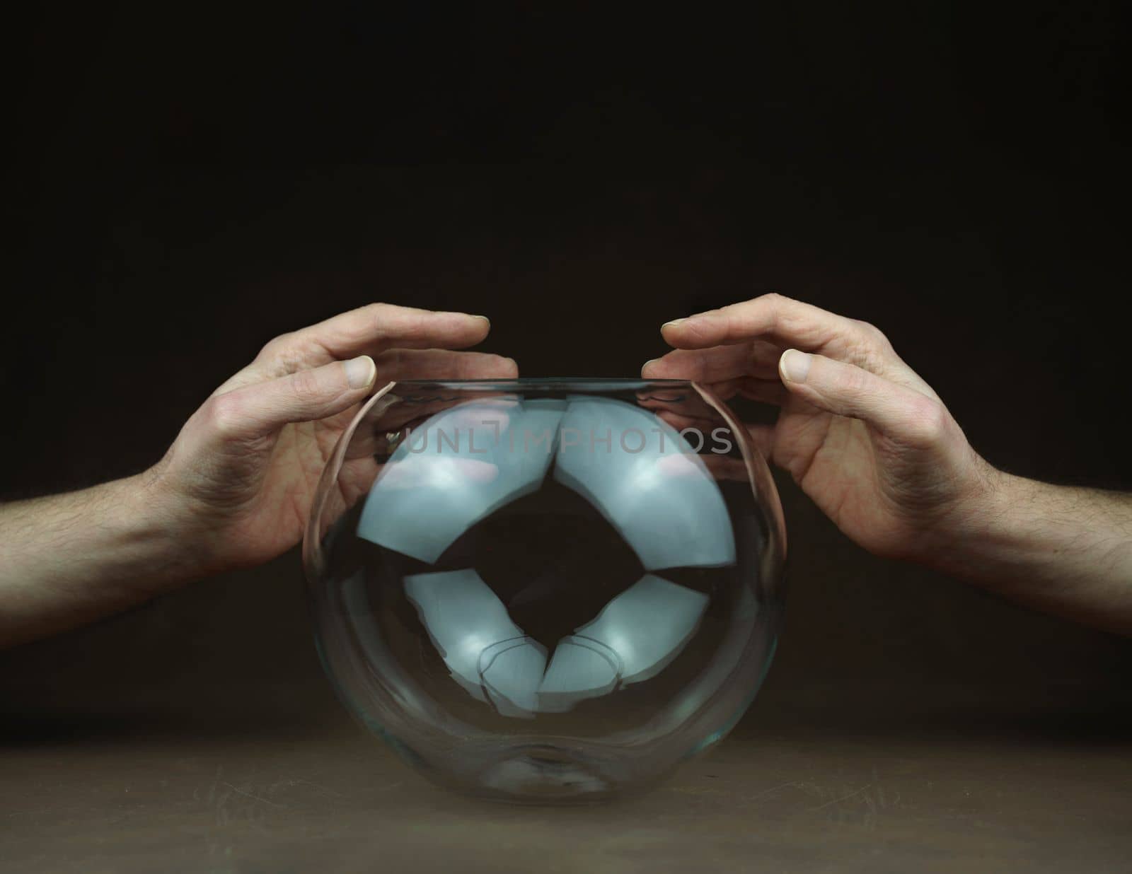hands over transparent glass ball by Costin