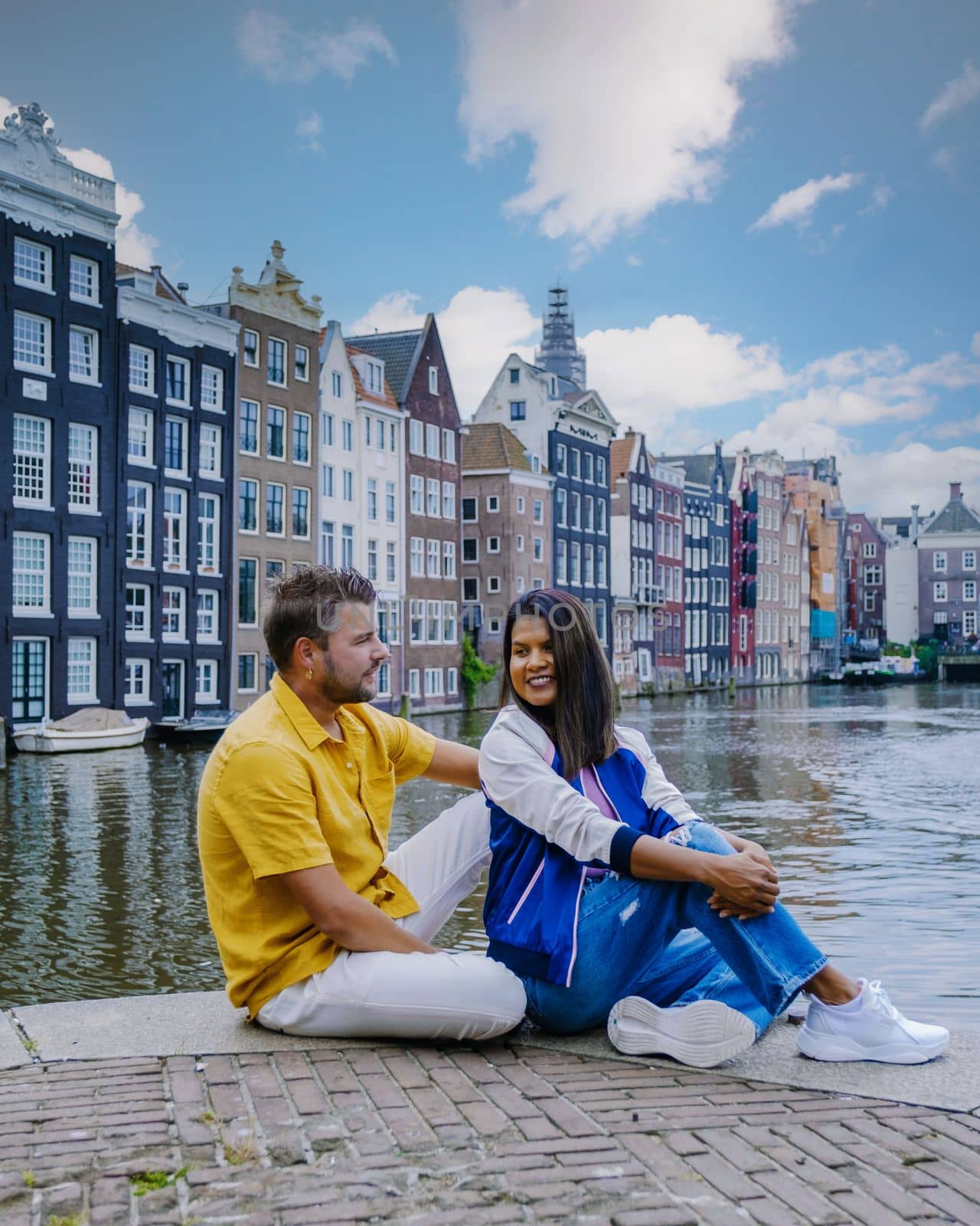 Amsterdam Netherlands, happy couple man and woman on a summer evening at the canals of Amsterdam by fokkebok