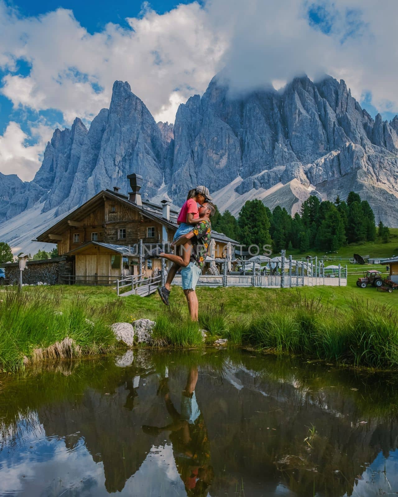 Geisler Alm, Dolomites Italy, couple hiking in the mountains of Val Di Funes in Italian Dolomites, Nature Park Geisler-Puez with Geisler Alm in South Tyrol. Italy man and woman hiking the mountains