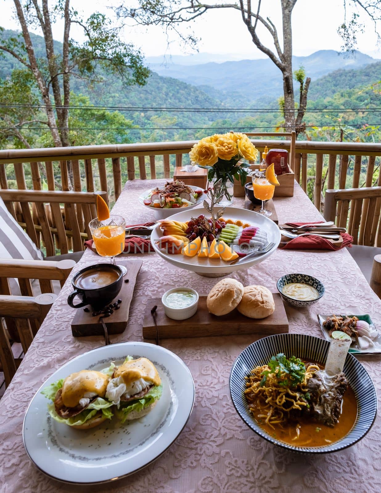 top view of a luxury breakfast in the mountains of Chiang Mai Thailand, luxury breakfast with Chiang Mai curry noodle soup or Khao Soi Gai and fruits and coffee on the table. 