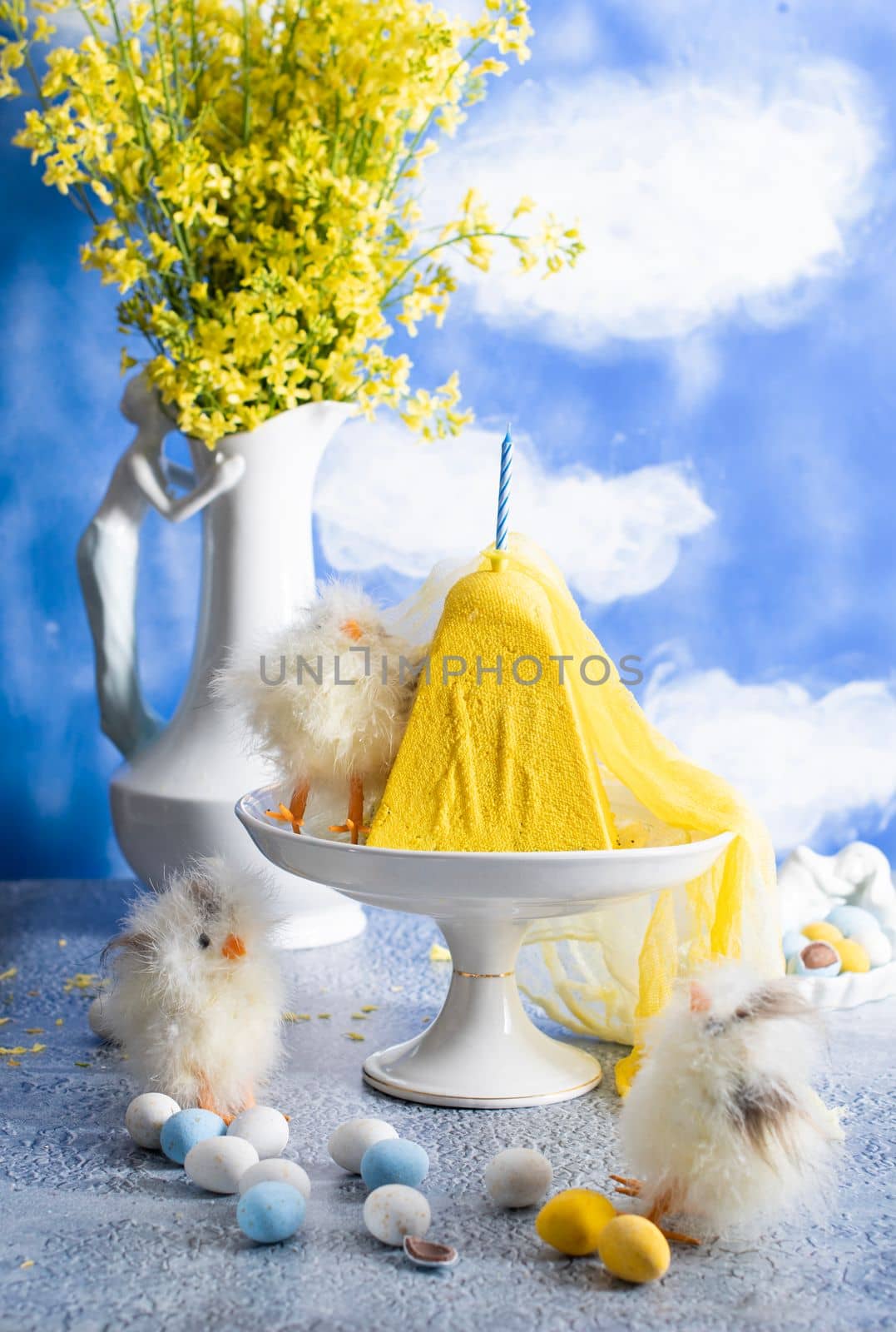 Traditional Easter Orthodox curd cake with yellow flowers against a blue sky with white clouds, High quality photo