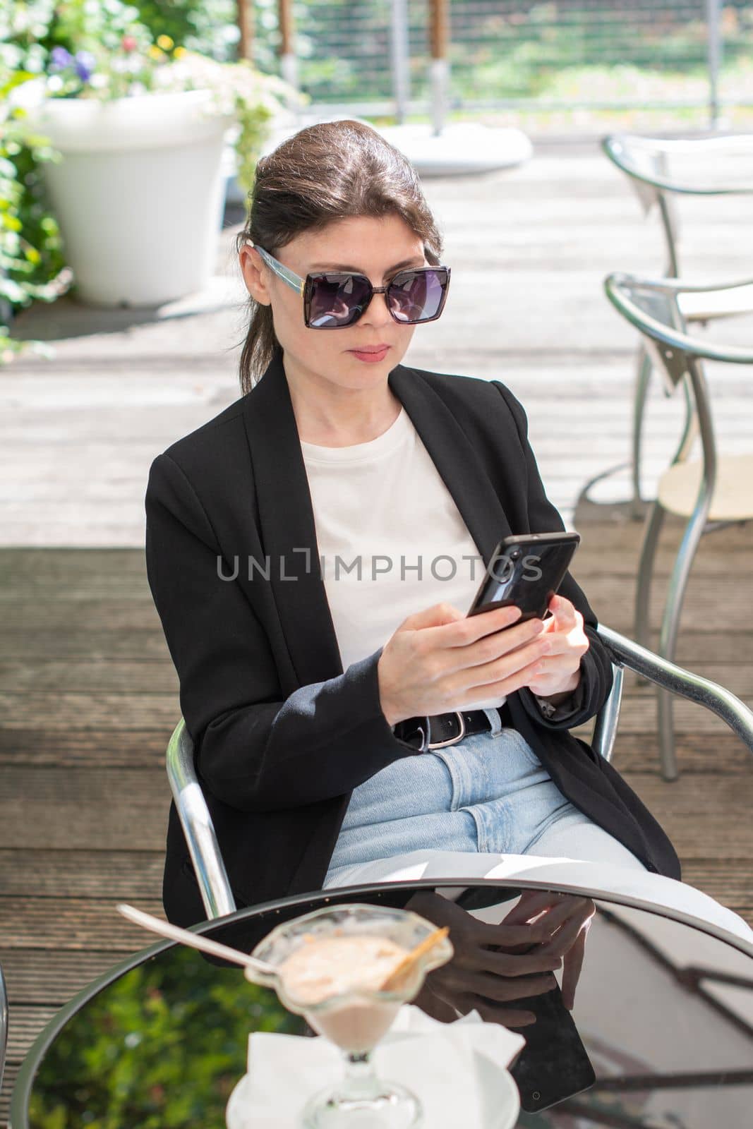 brunette woman chatting in a smartphone at a table in a cafe, High quality photo