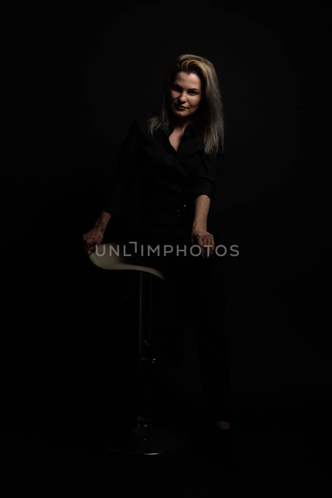 woman in black on a black background.