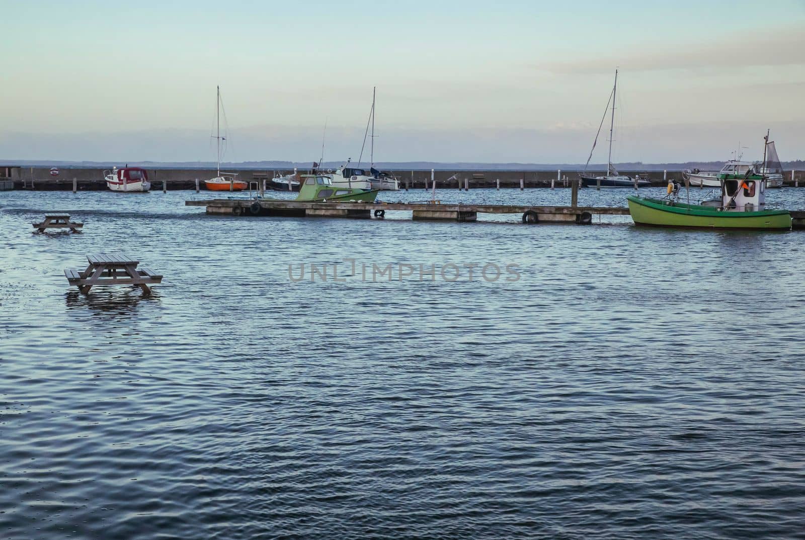 Picnic tables set in the North Sea at a ferry port in evening Denmark.