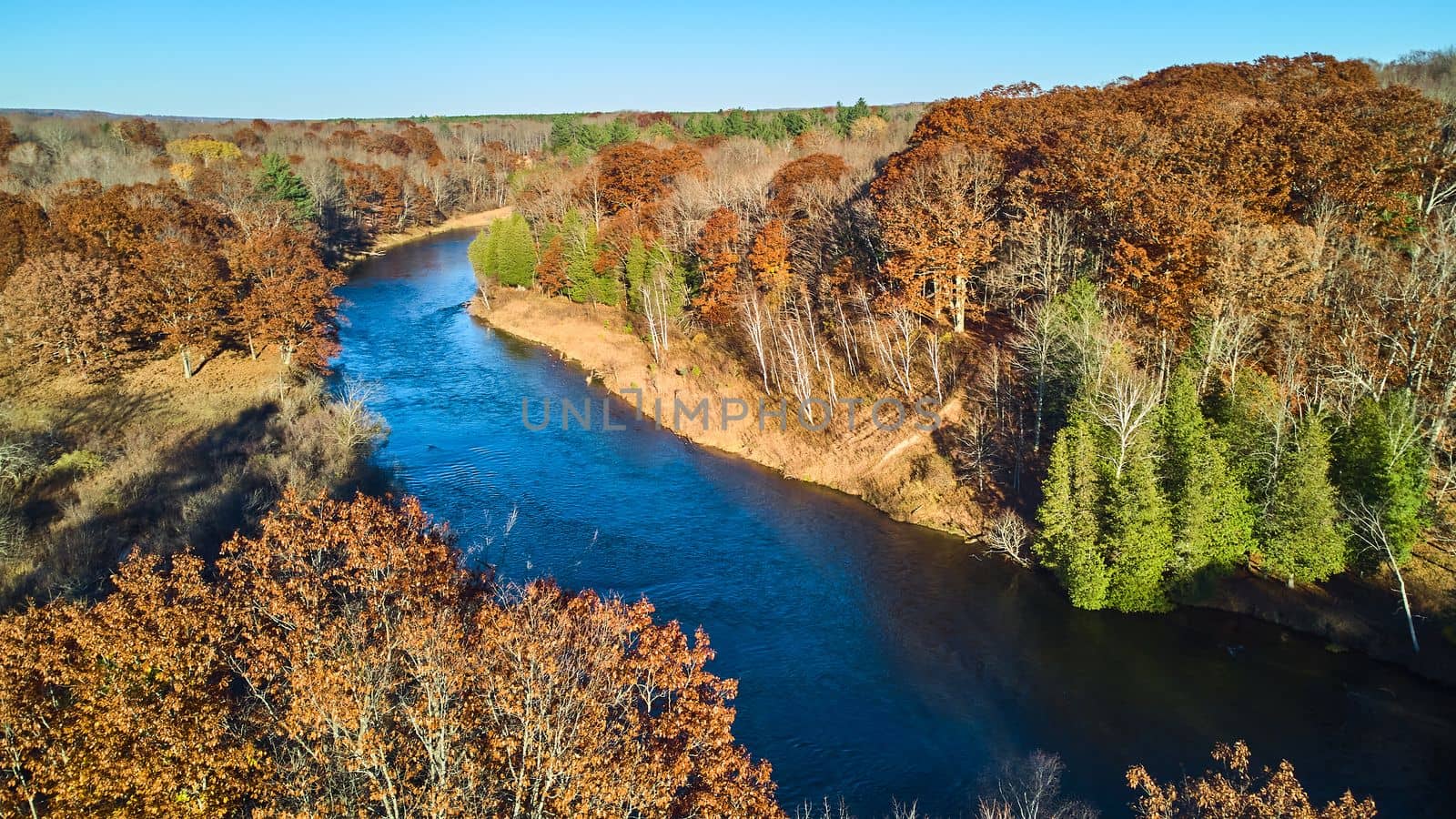 Warm colored forest aerial with large blue river by njproductions