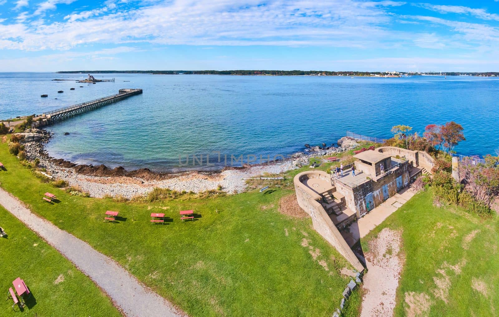 Image of Old military fort on coast of Maine with pier and small island lighthouse in distance