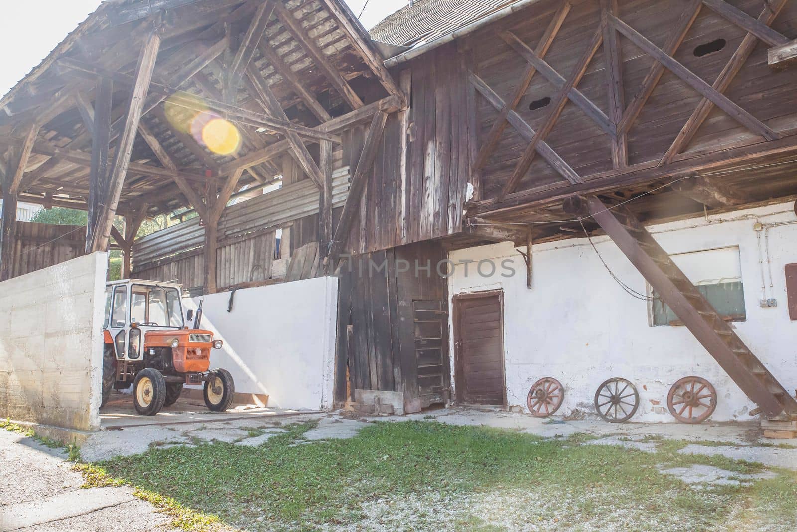 Old barn with a tractor in an Alpine village in Slovenia.