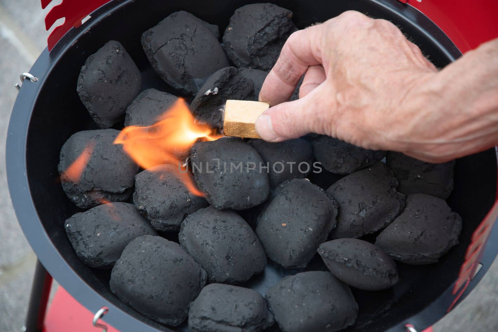 a man lights a fire with a lighter special charcoals for a barbecue a barbecue house on the terrace prepares a place for a barbecue. High quality photo