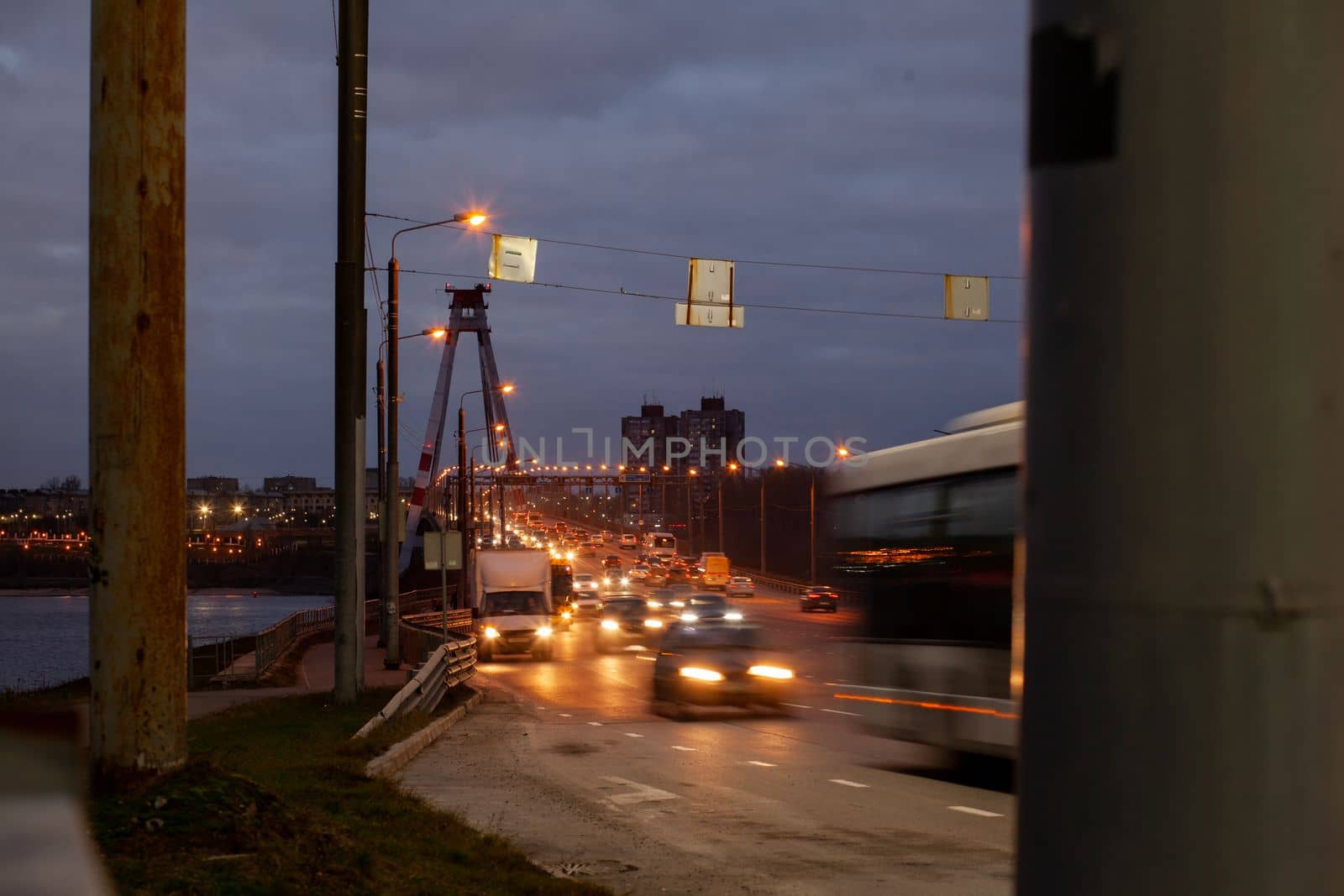 29.11.2022, Cherepovets, Russia. A large automobile bridge on which cars drive at night. A bridge with large columns and lighting. Cars are driving over the bridge