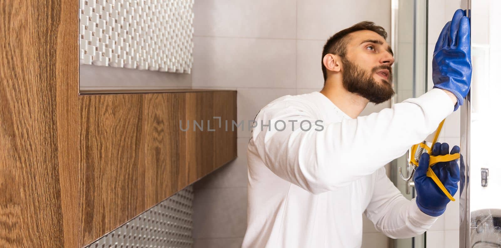 Plumber installing a shower cabin in bathroom.