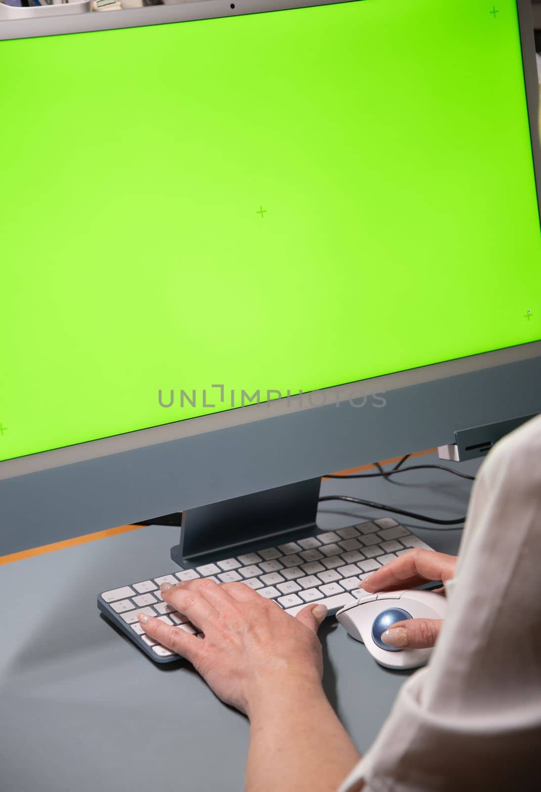 woman sitting at home in front of green screen monitor with a green screen and chatting. High quality photo