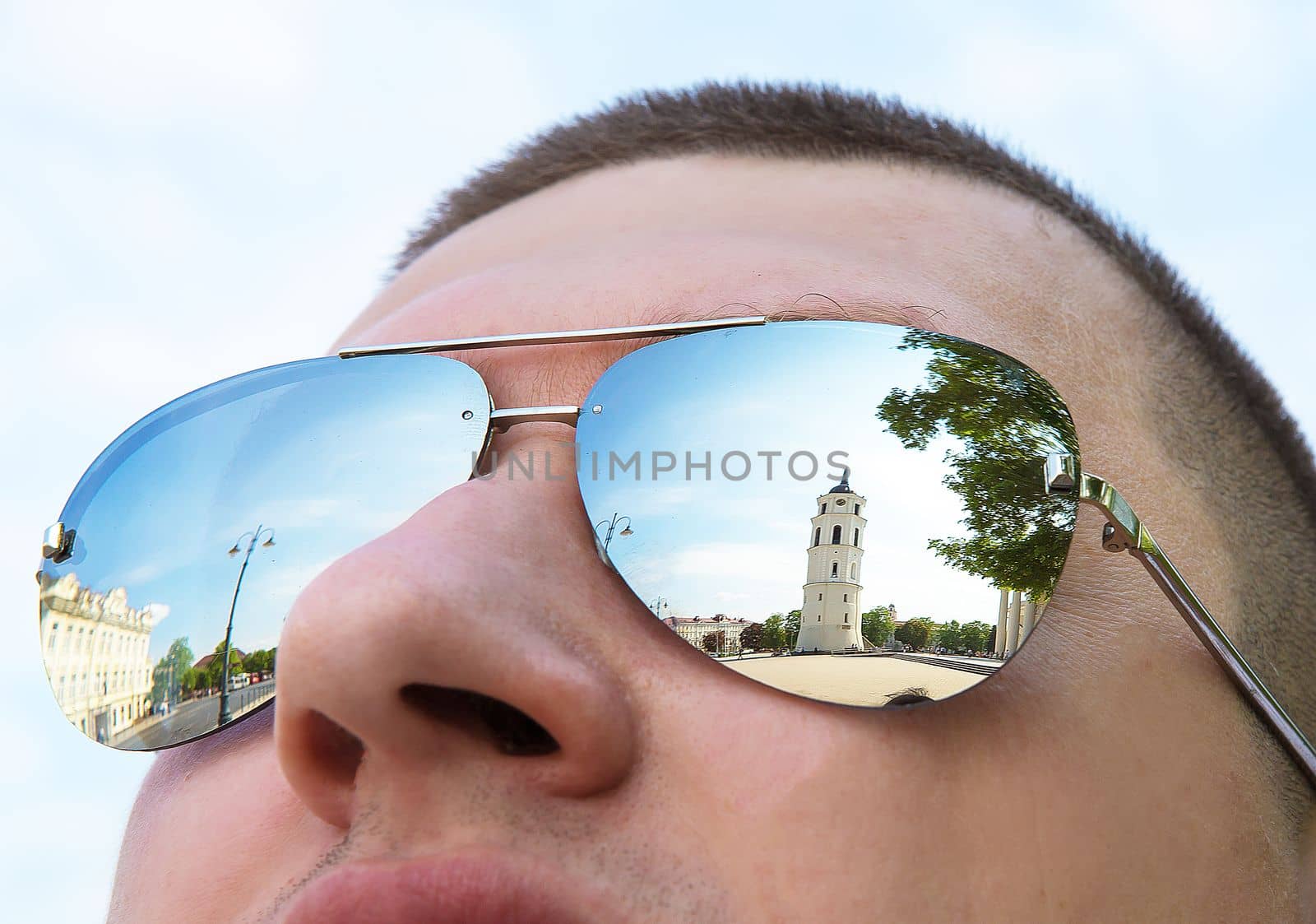 The beautiful city of Vilnius is reflected in a man sunglasses