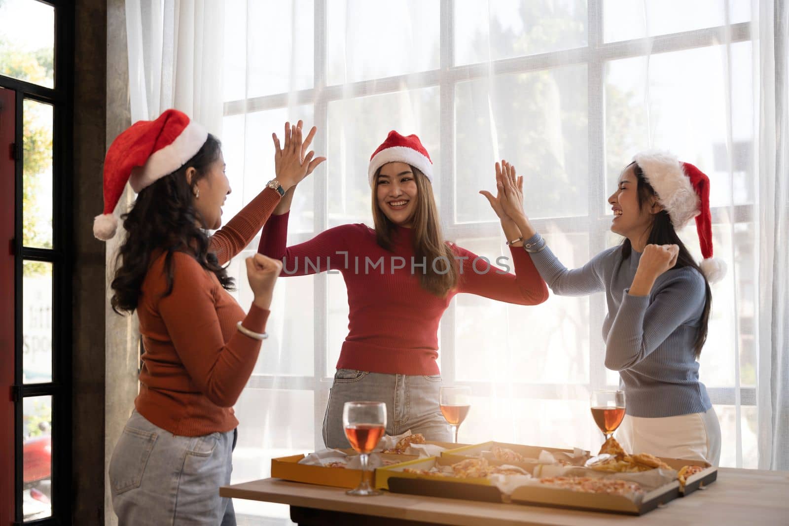 Group of young asian office girl friends having fun, talking and eating pizza together with happiness and fun. Lifestyle Concept by wichayada